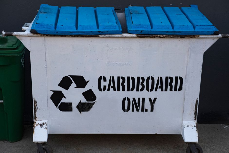 A white recycling container marked 
